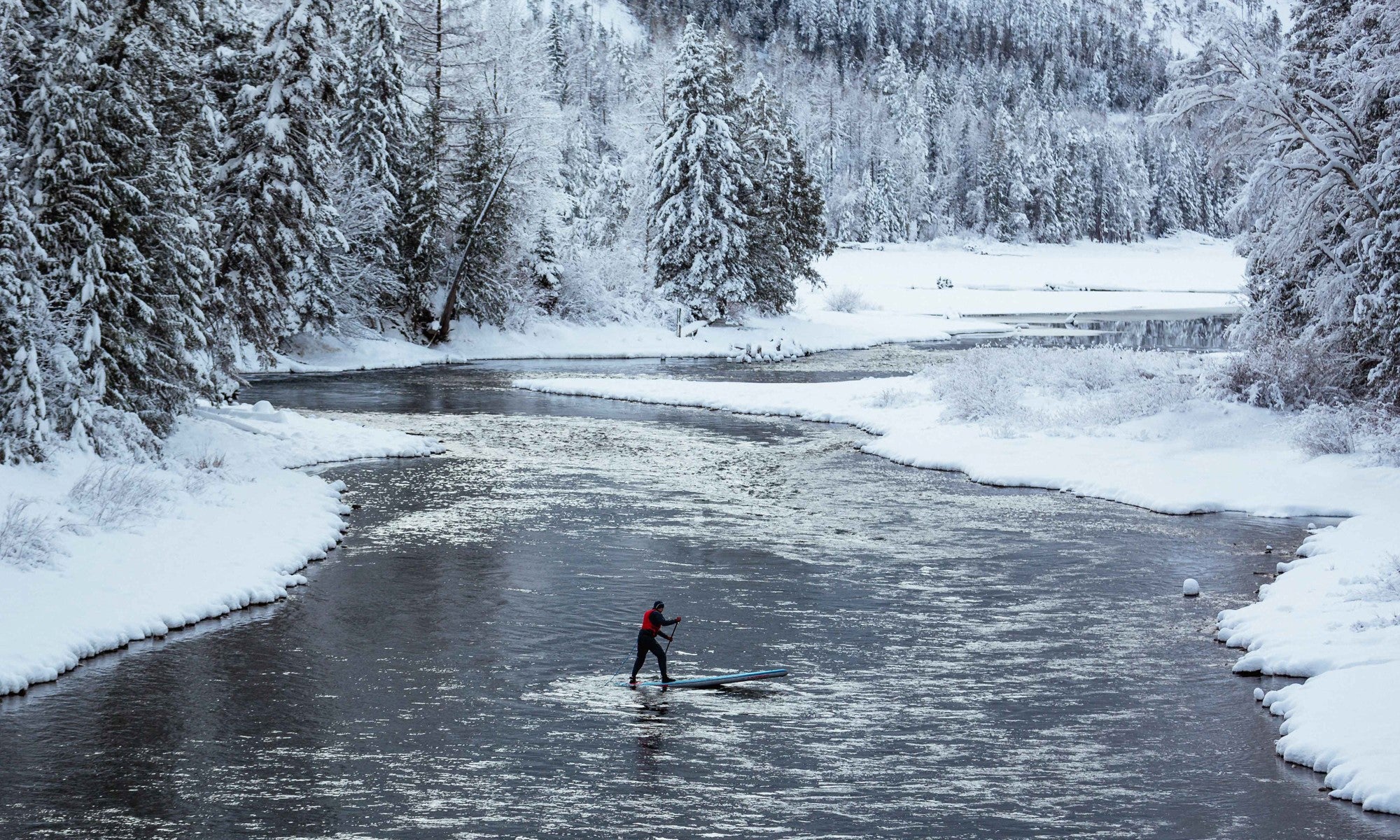 paddle boarding in a snowy creek