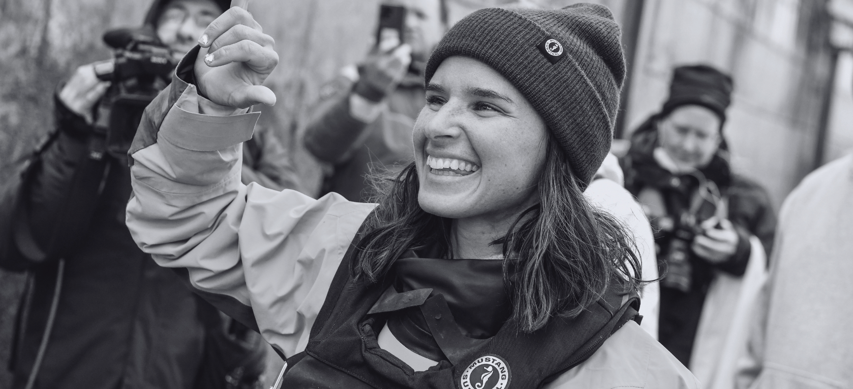 Victorious ambassador smiling on deck after a win, dressed in Mustang Survival gear maintained for lasting waterproof performance.