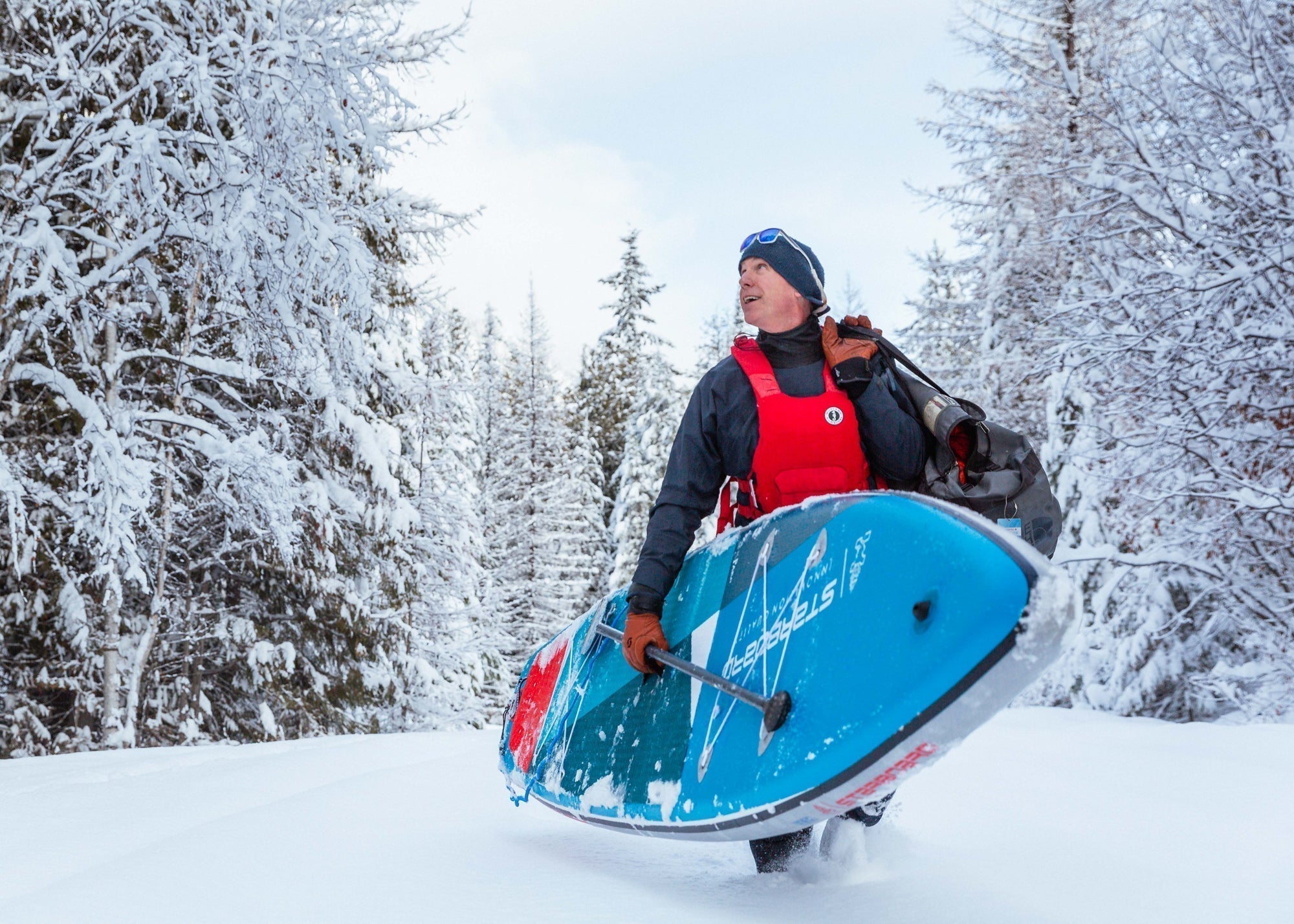 Stand up paddle boarder in dry suit ready for winter conditions