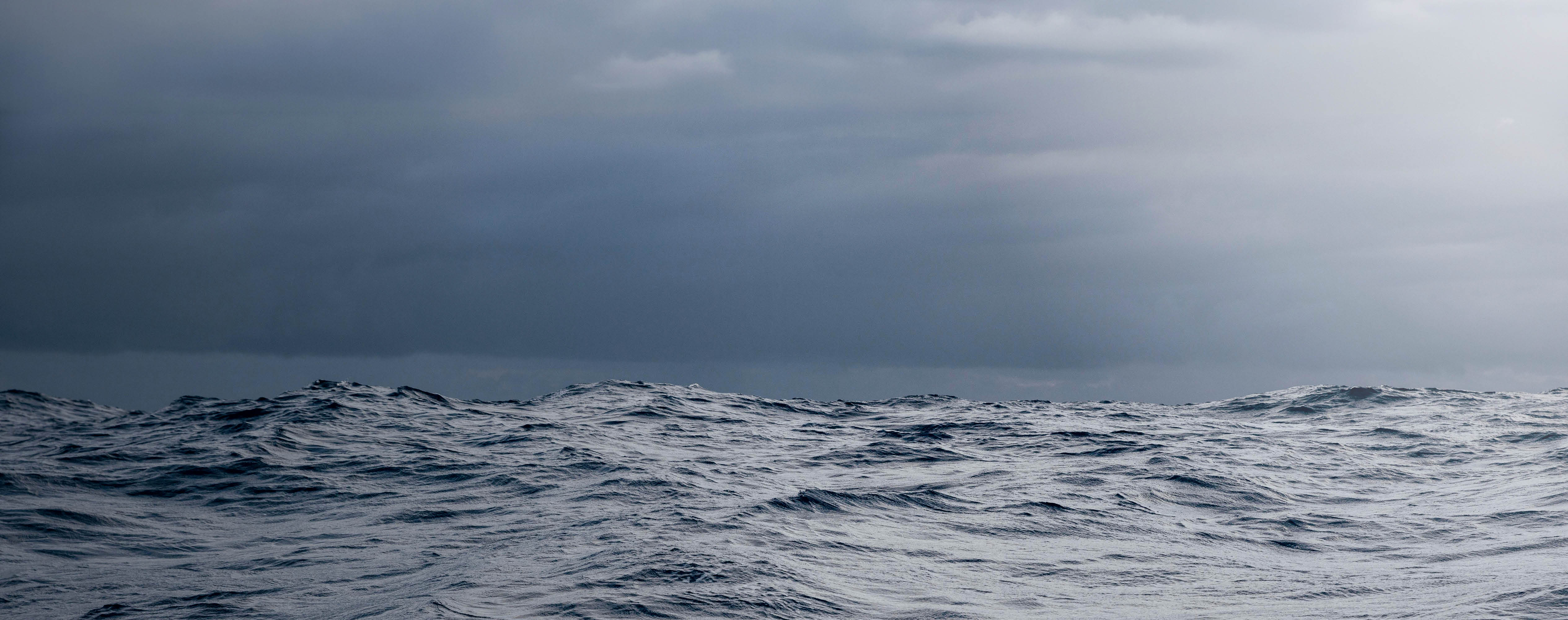 Dark blue ocean with small waves under a cloudy gray sky